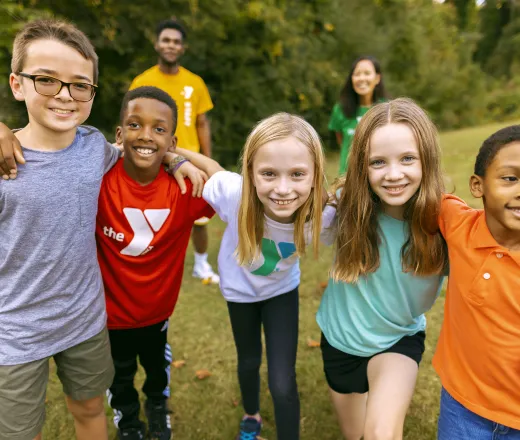 camp participant smiling faces outside with counselors