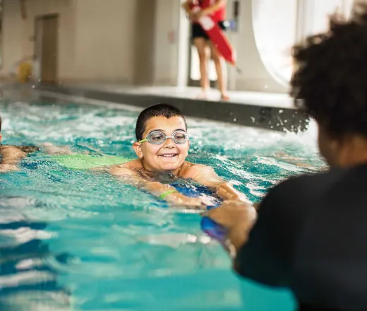 child in the water with a ymca swim instructor