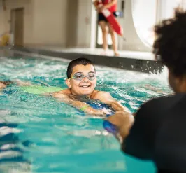 child in the water with a ymca swim instructor